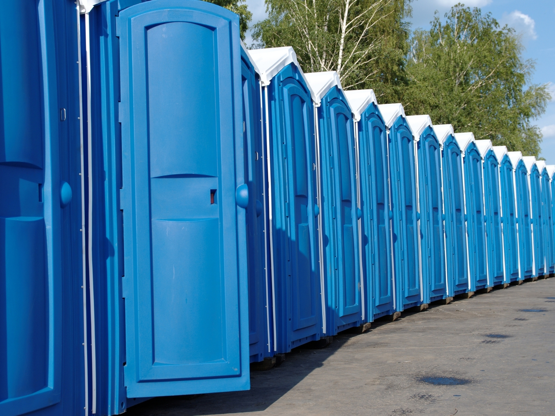 A long bank of portable restrooms lined up along an event footprint